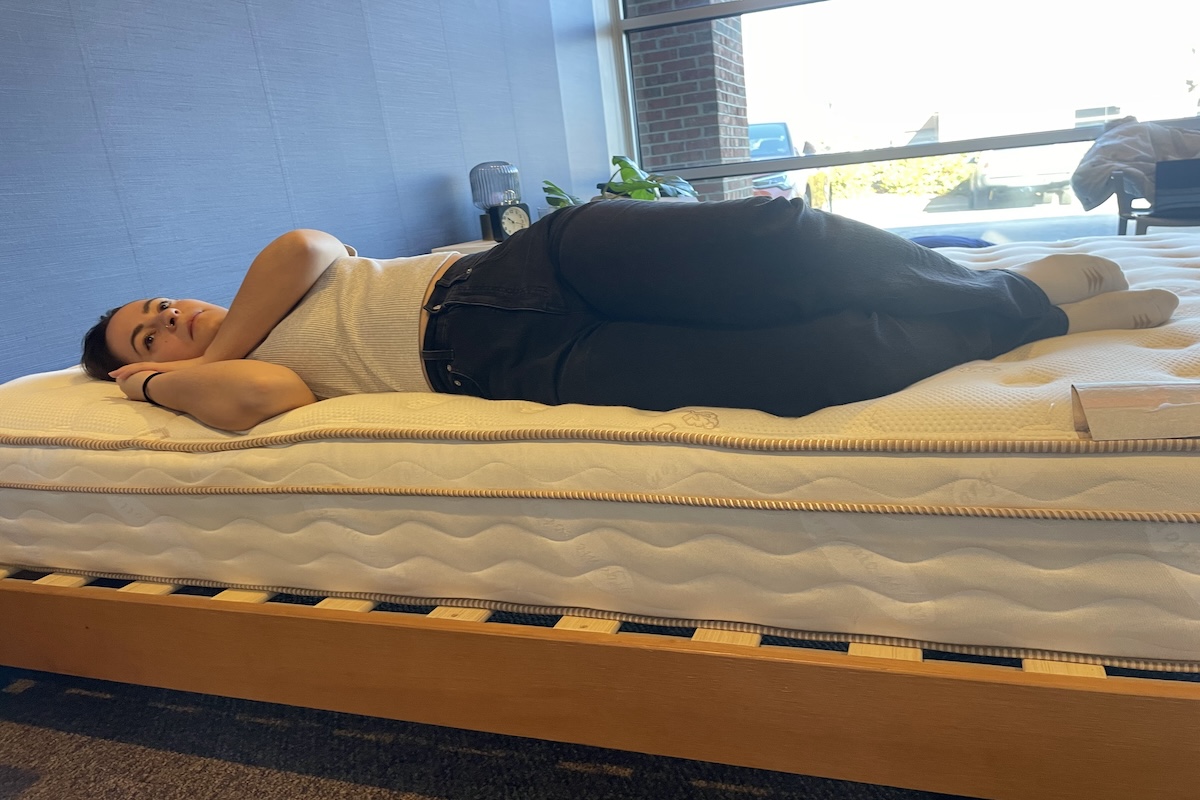 A woman lays on the Saatva Classic during testing