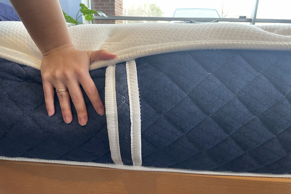 Our tester pushes their hand down on the Brooklyn Bedding Signature Hybrid