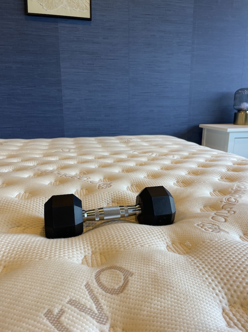 a 10-pound dumbbell on a Saatva mattress