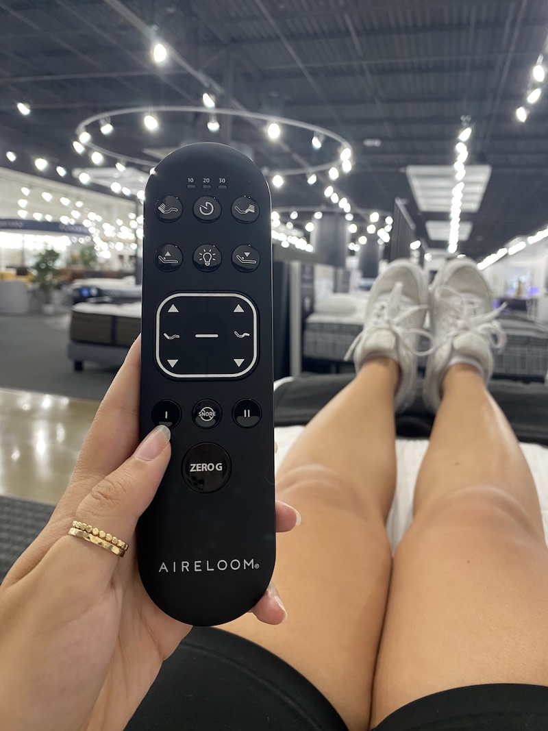 Person lying on an adjustable bed while holding a remote
